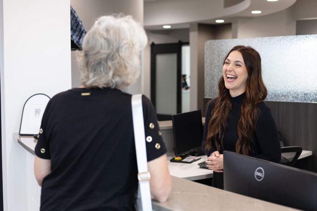 Patient talking to front desk attendant.